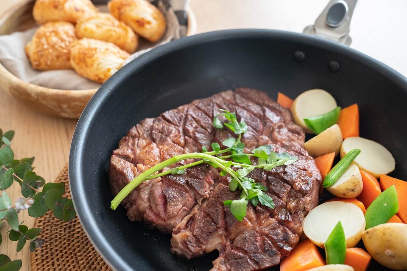 PENTAフライパンで焼かれたジューシーなステーキ。高い蓄熱性で、野菜と共に美味しそうな焼き色がついている様子。