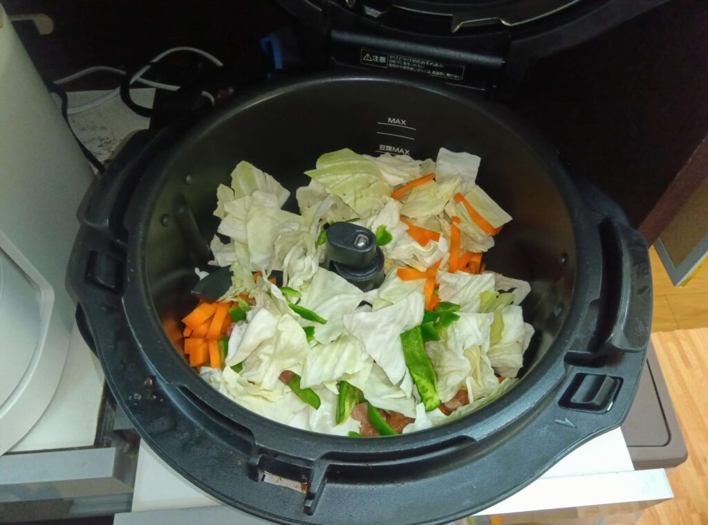 オートクッカービストロNF-AC1000の内なべにキャベツ、にんじん、ピーマン、豚肉を入れた野菜炒めの調理前